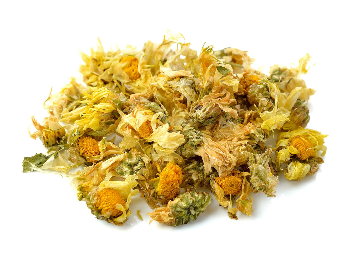 The image shows dried chrysanthemum flowers, which are commonly used to make herbal tea. These flowers are light yellow with hints of green and orange, indicating their natural, sun-dried state.