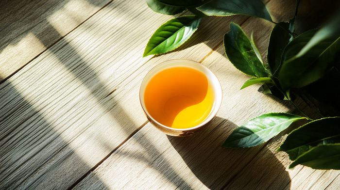 Loose leaves of Da Hong Pao oolong tea on a wooden surface, symbolizing its rich, earthy flavor and calming effects for anxiety relief.