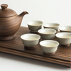 Traditional Chinese tea set with a wooden teapot and eight ceramic teacups arranged on a matching wooden tea tray against a white background.